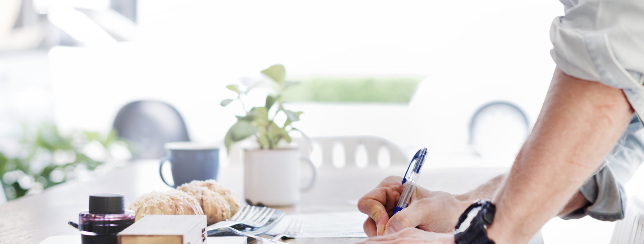 Pen in hand writing on a desk